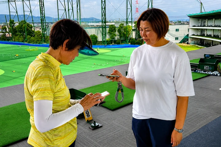 生徒とインストラクターがスマートフォンでQRコードを読み取る様子